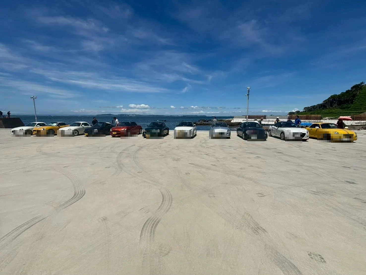 海辺の駐車エリアに集まった仲間と愛車