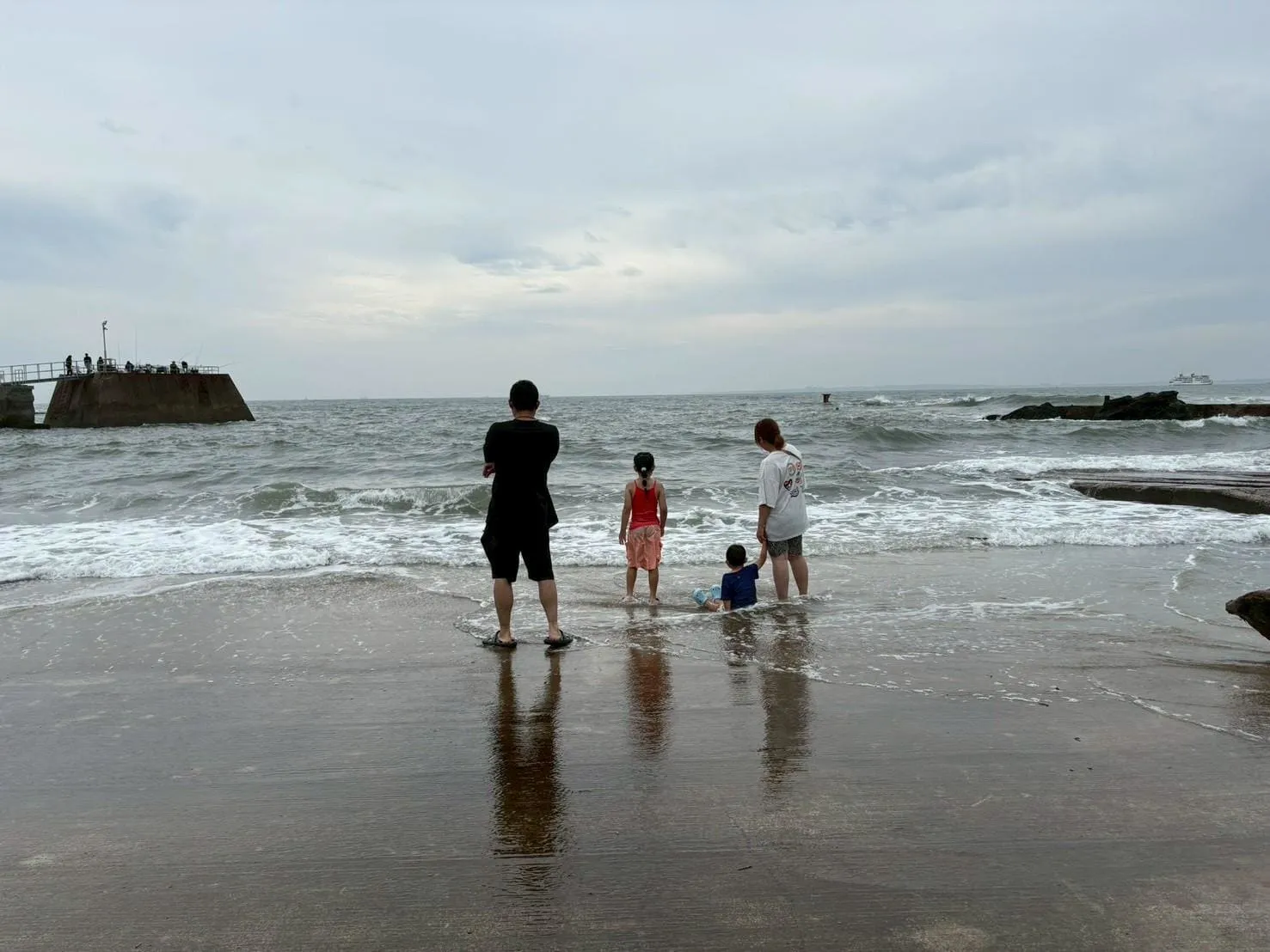 波打ち際で海に入る親子