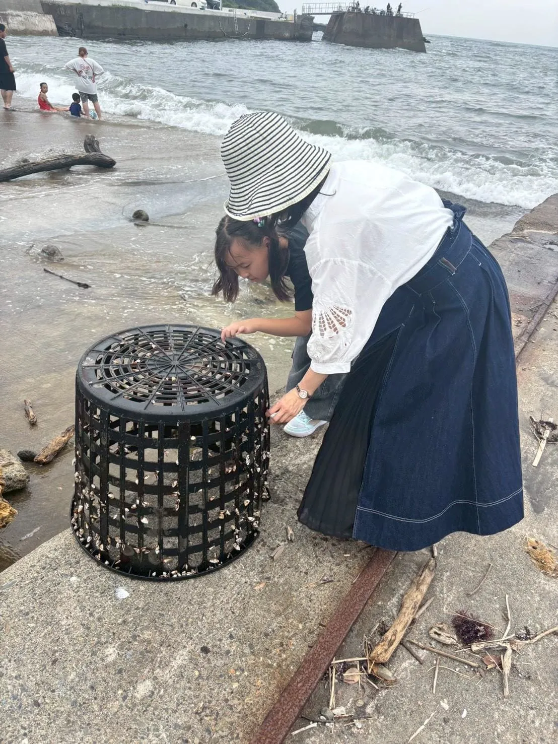 漂流物の魚アートに親子で飾り付けをする様子